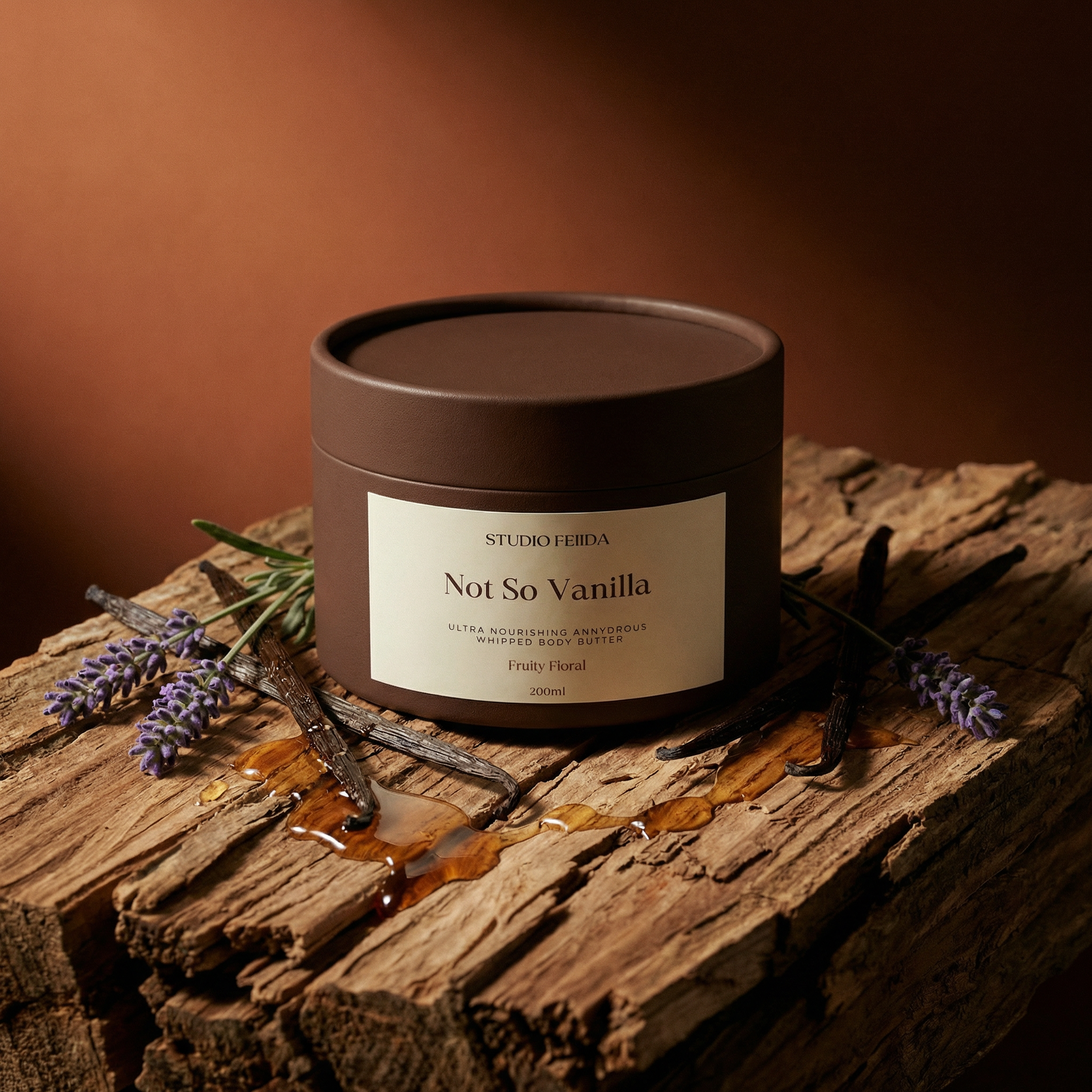 Candle labeled 'Not So Vanilla' on a wooden surface with vanilla beans and lavender.